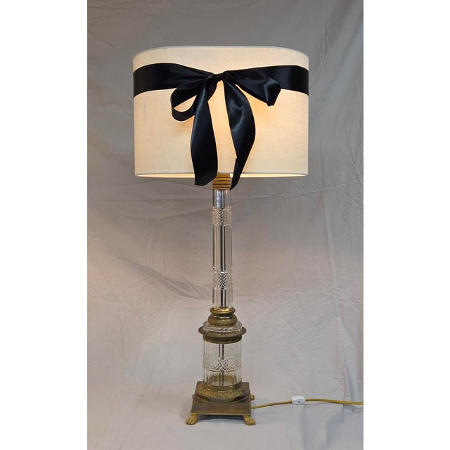 A stunning, elegant pair of mid-century crystal column table lamps accented with brass and bronze fittings in the style of...