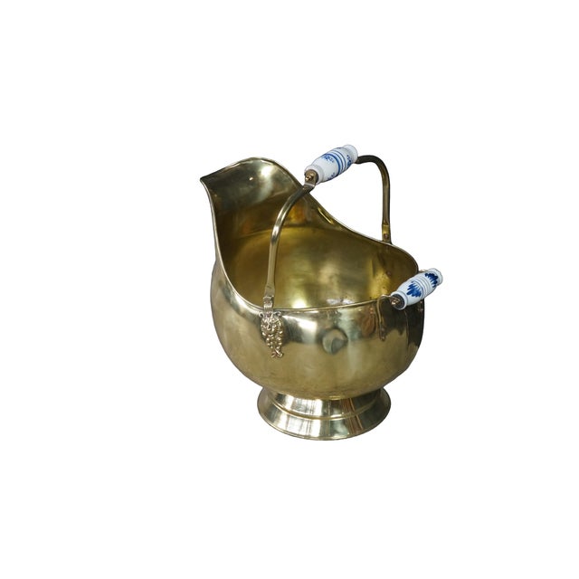 This antique Dutch-style brass coal scuttle or fireside ash bucket displays a highly decorative, helmet-shaped silhouette...