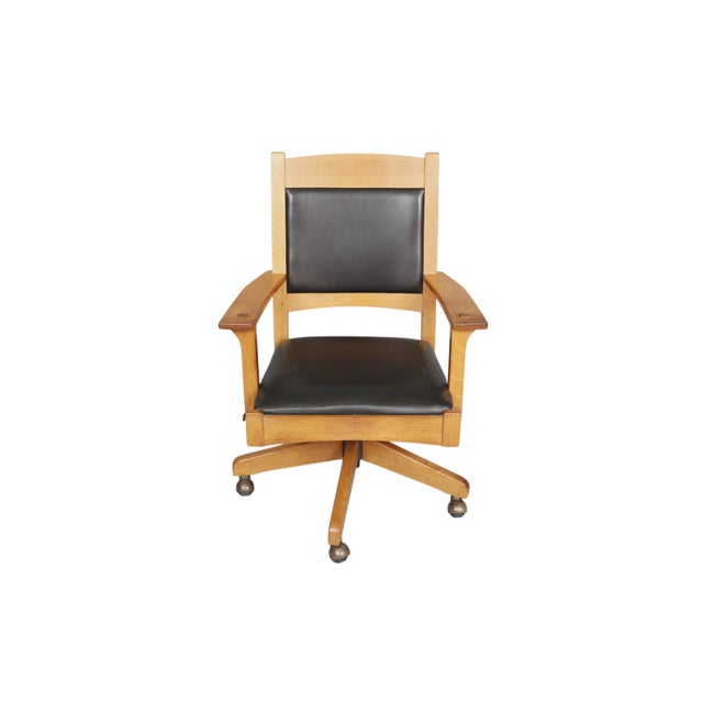 A Mission style swivel and tilt desk chair made by Stickley Furniture. The square oak frame is made of plank wood, the...