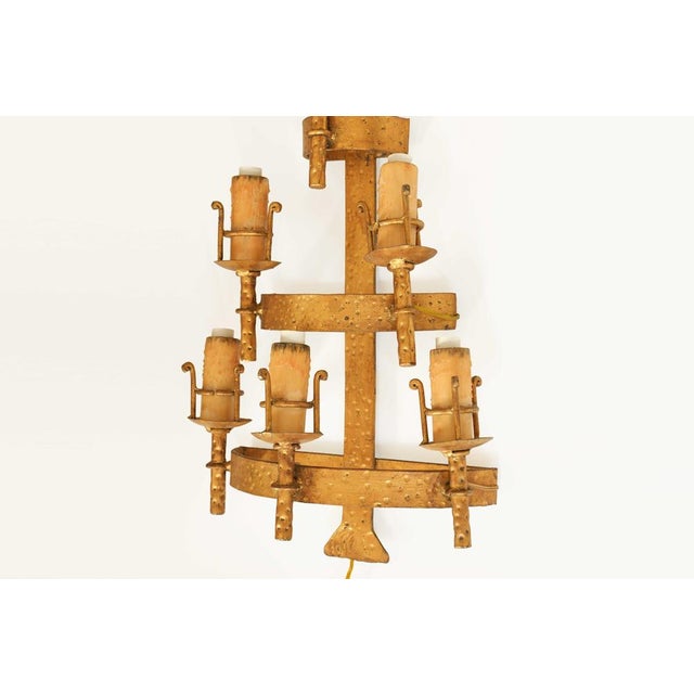 A striking and highly decorative vintage wrought iron wall sconce featuring an architectural, tiered design with six...