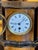 English walnut mantel clock of architectural form with a shaped top and stepped base, the figured walnut case with...