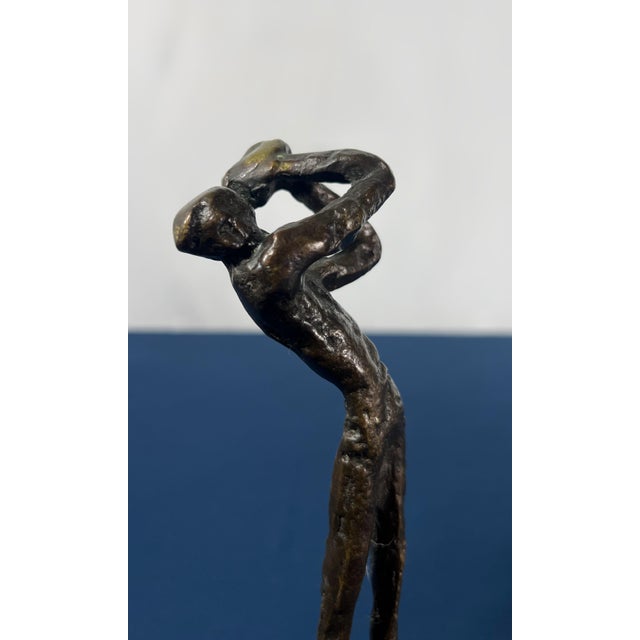 This striking cast bronze study captures a moment of intense kinetic energy and modern tension. Featuring the elongated,...