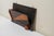 Art Deco style wall-mounted letter or magazine organizer. It features a dark back panel with metal hooks and a front...