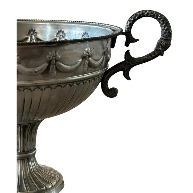 Wine Pedestal Bowl with Bows & Ornate Handles is a stunning piece of tableware, characterized by its elegant design and...