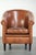 This vintage sheepskin club chair features a warm color scheme and is finished with black piping and a separate seat...