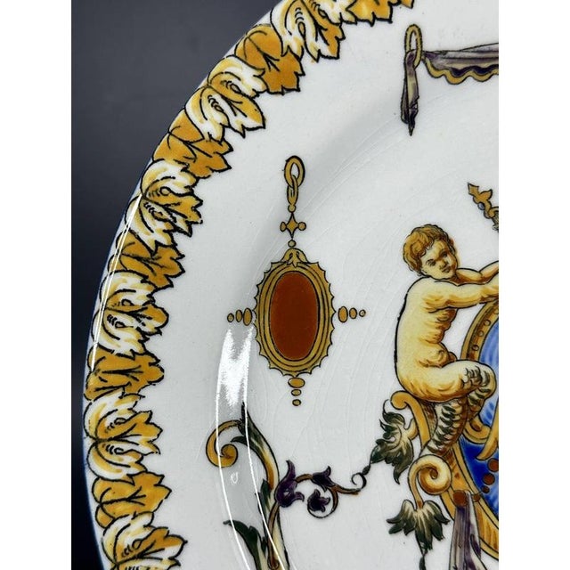 This very colourful hand painted pottery dish by Gien of France is decorated with a central faux armorial flanked by...