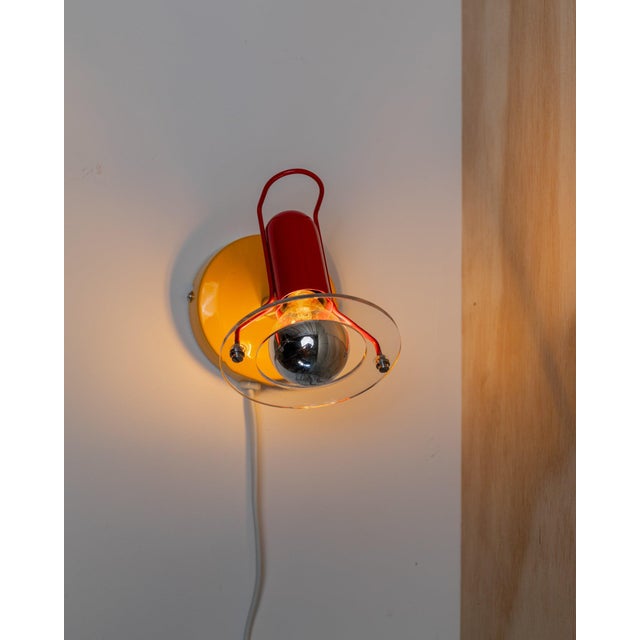 Discover this vintage wall lamp from Paulmann from the 1980s in postmodern Memphis style. The colourful design made of...