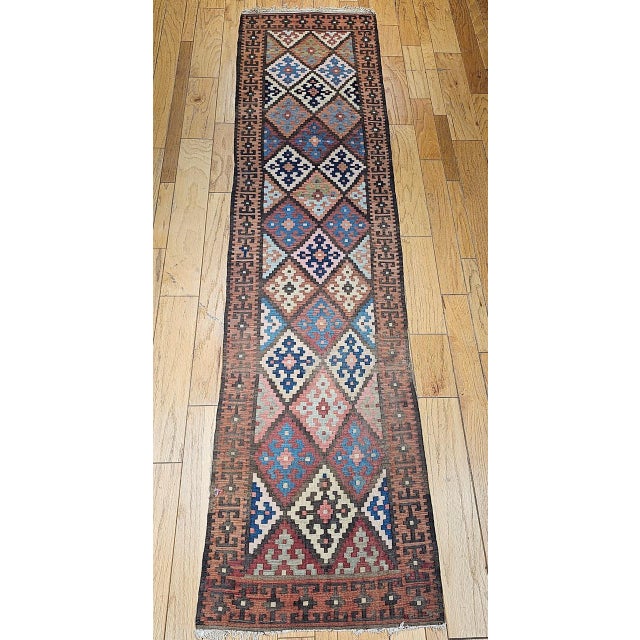Vintage Persian Varamin Kilim Runner, a handwoven treasure from the historic village of Varamin in north-central Persia....