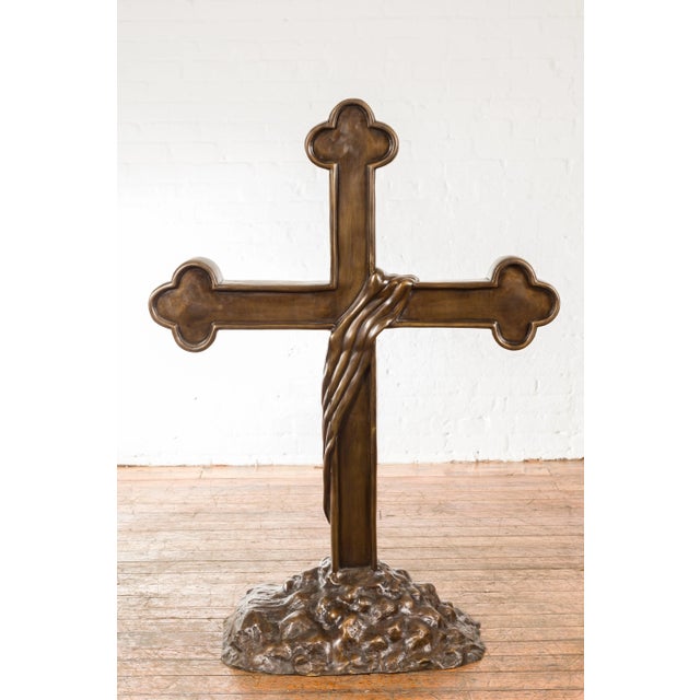 A contemporary lost wax bronze religious cross with trifold extremities and rocky base. Created with the traditional...
