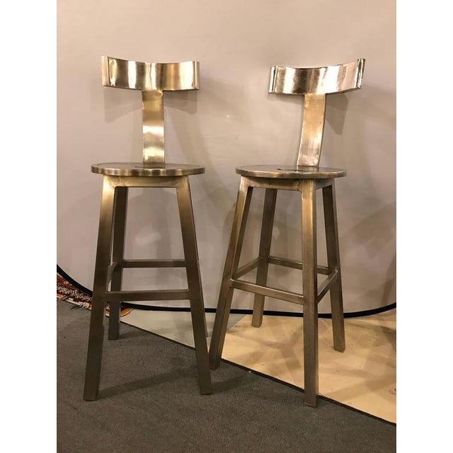 A Pair Of Deco Style Steel Bar Stool. Each having a 30" seat to floor. The circular seat leading to a T shaped back on...