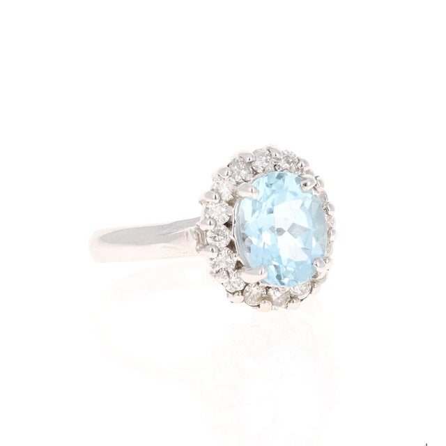 This ring has a pretty 2.31 carat gorgeous Oval Cut Aquamarine set in the center of the ring and is surrounded by 16 Round...