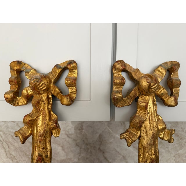 A striking pair of vintage giltwood wall sconces by Decorative Crafts Inc., Hand Crafted Imports. Beautifully carved with...