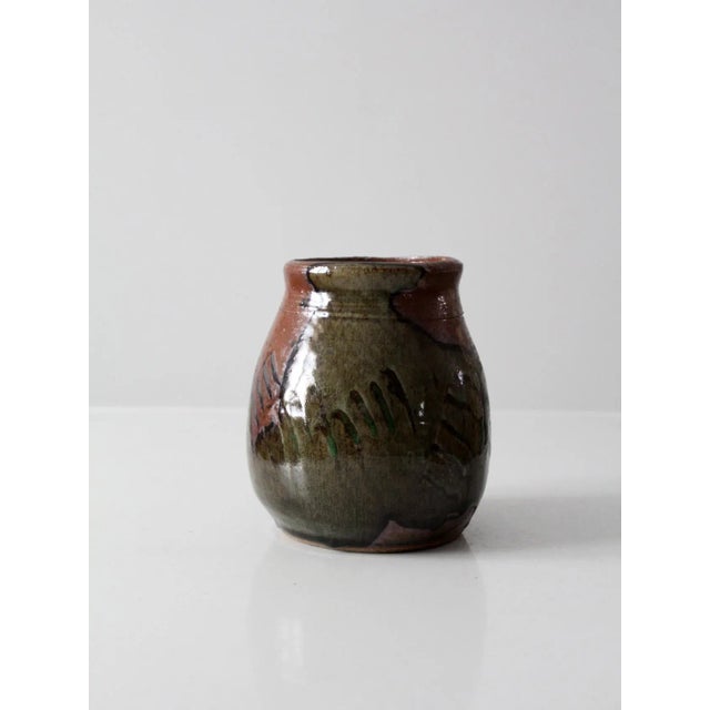 A vintage studio pottery vase with a substantial, hand-crafted form and expressive green and brown glaze. Signed by the...