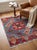A hand-knotted Afghan rug in the Kazak design, woven on a denim blue field with a large madder red medallion at its...