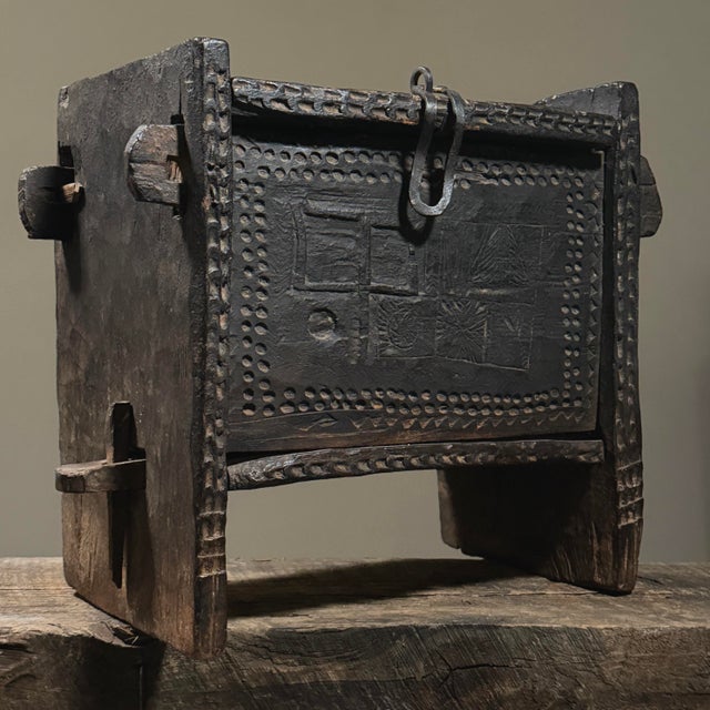 The surface features chip carved geometric designs and a central symbolic motif, possibly referencing cultural or...
