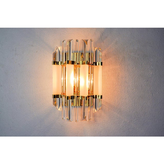 Very beautiful Venini wall lamp produced in Italy in the 70s. Triedi crystals supported by a gold metal structure. Unique...