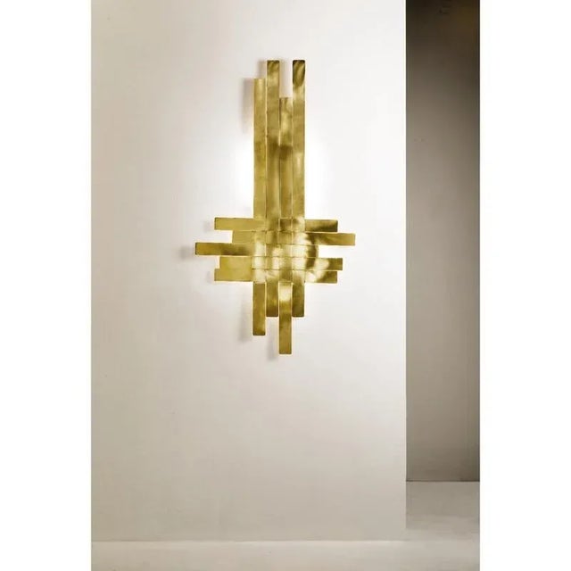 Rs400 wall lamp in woven satin brass by daluce dimensions: d 6 x 75 x h 115 cm. Materials: brass. All our lamps can be...