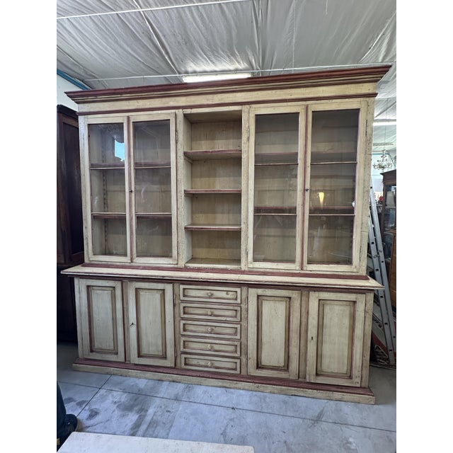 This Marche-style display cabinet features an ivory lacquer finish with aubergine/purple trim. The cabinet features glass...