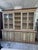 This Marche-style display cabinet features an ivory lacquer finish with aubergine/purple trim. The cabinet features glass...