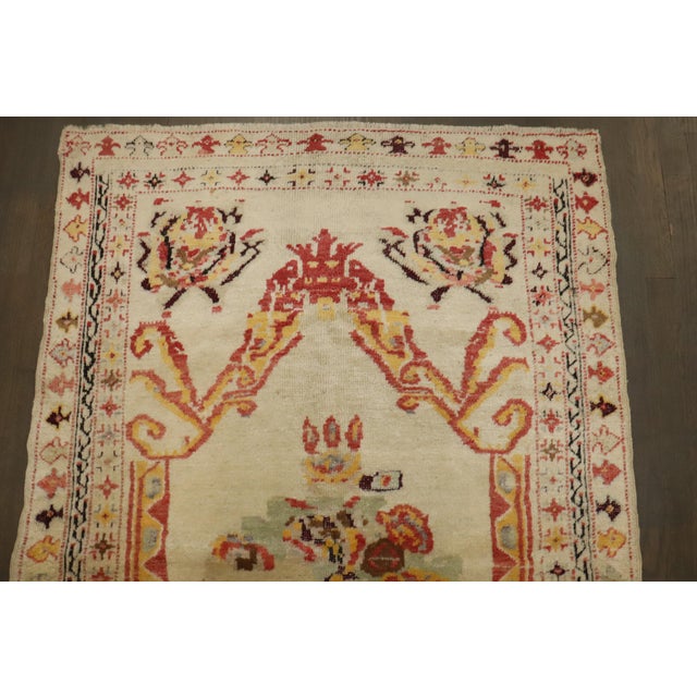 An early 20th-century Ivory field Turkish ghiordes small size rug. 3'6'' x 5'4''