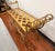 A sculptural gilt-metal bench with graceful scrollwork arms and an open lattice seat. Its warm, timeworn finish adds...