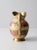 This is a cloisonné pitcher circa early 20th century. The brass ewer features a lush floral enamel design in cream, pink...