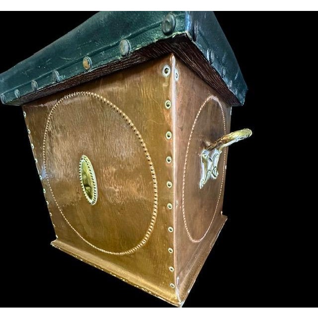 Handsome early 20th century English campaign-style storage ottoman or footstool, crafted in copper-clad wood with brass...