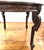 Elegant vintage dining table featuring hand-carved scroll and foliate detailing along the apron and legs. The table...