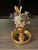 Artisan made by Elia small sea Shell art floral arrangement in gold porcelain stand on a small ormolu mirrored round tray.