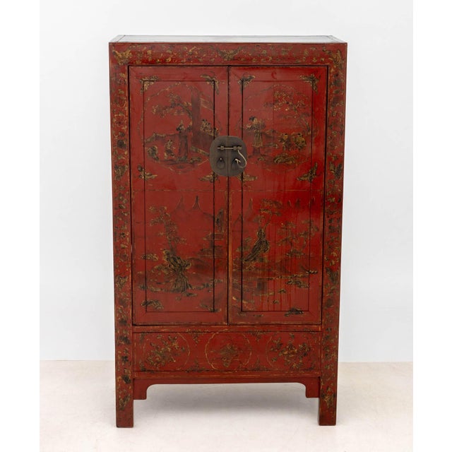 Chinese Red Lacquered Cabinet, with gilt decorated figural courtyard scene, the two doors opening to one shelf. 63" H x...