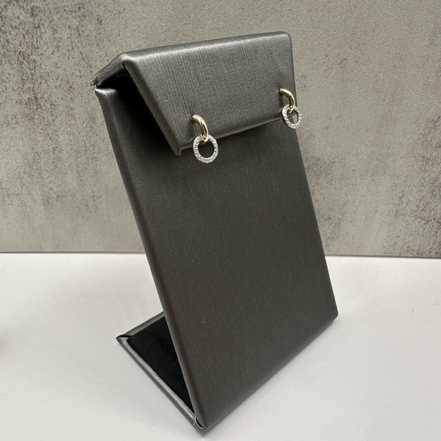 These delicate diamond circle drop earrings in 14kt yellow gold feature 0.08 carats total weight of natural GH SI2–I1...