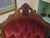 A striking late 19th-century American Victorian armchair showcasing the richly carved walnut craftsmanship and dramatic...