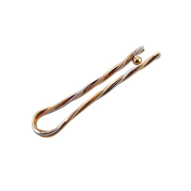 Experience the timeless elegance and storied heritage of Cartier with this exceptional 18K Tri-Color Gold Trinity Tie Pin....