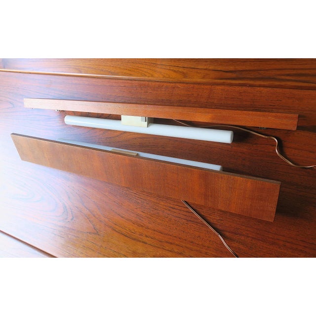 Unusual pair of Danish teak wall shelves with incorporated wall or reading lights dating from the 1960s.