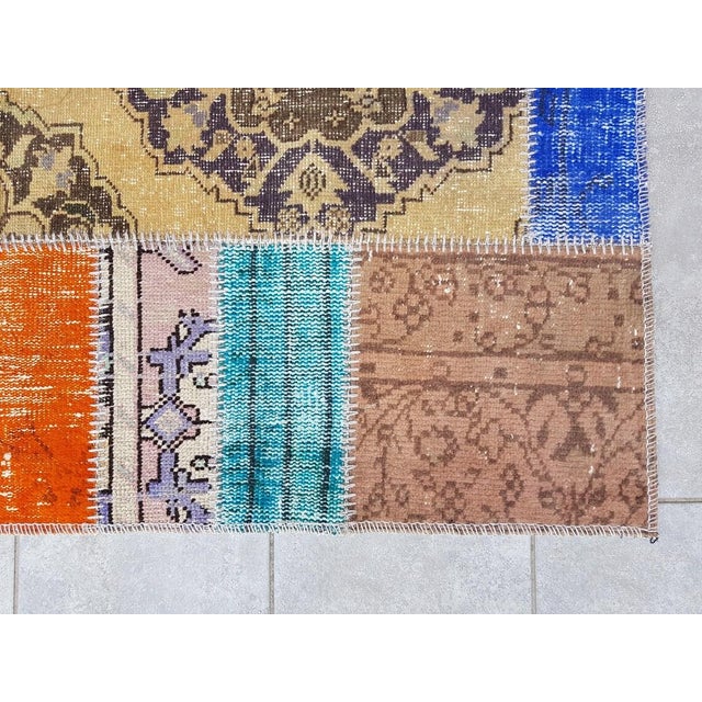 This is a vintage Turkish Oushak rug from the Mid 20th Century. The piece was hand-knotted.