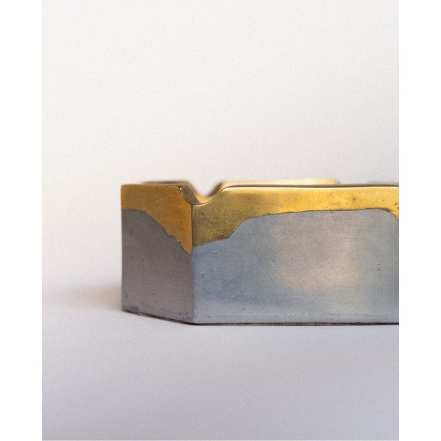 Designed by David Marshall, this square brass ashtray pairs a heavily textured brass frame with a smooth aluminium centre....