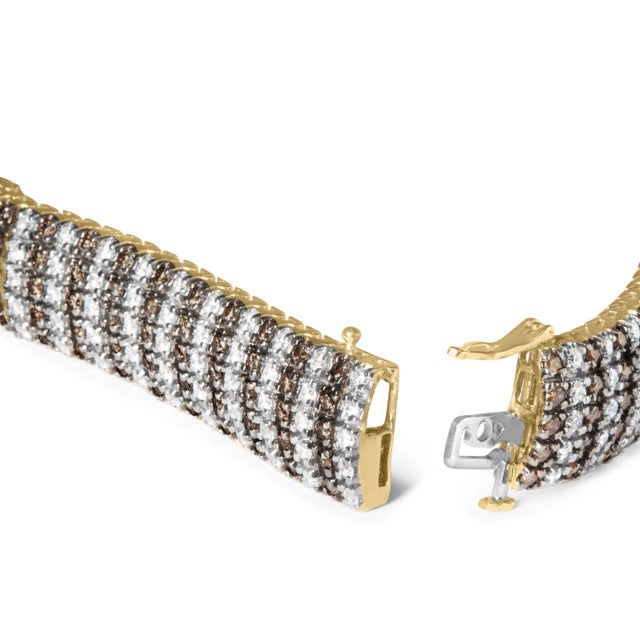You've never seen glamour like this 10 1/3 carat diamond tennis bracelet. Set in 10k yellow gold sits rows of natural...