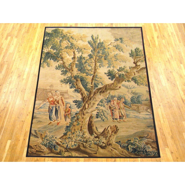 A French Aubusson rustic tapestry from the late 17th century, depicting several villagers on either side of a large tree...