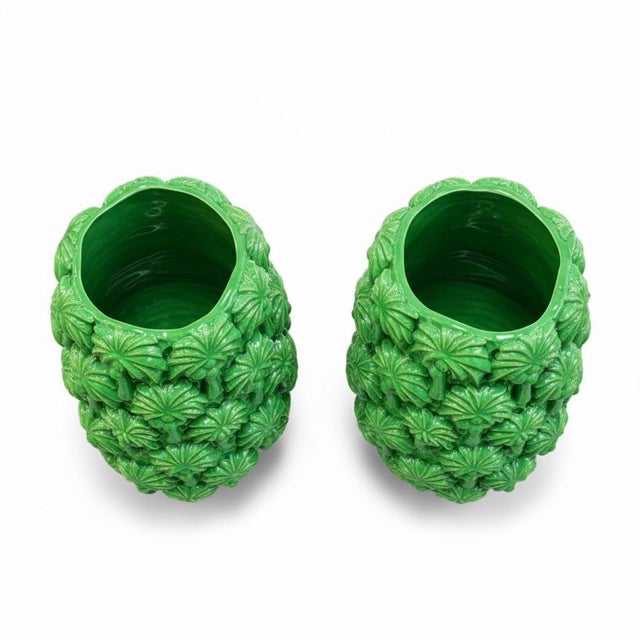Striking pair of ceramic vases finished in a vibrant emerald-green high-gloss glaze. Each features an all-over relief of...