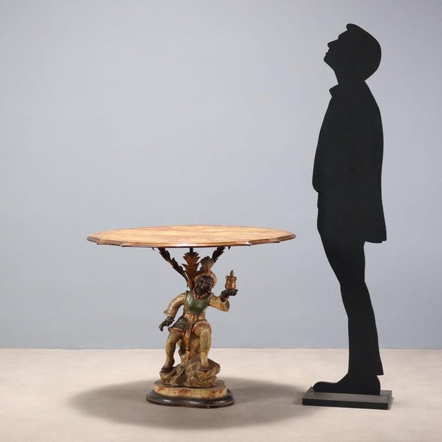 Coffee table with painted metal moorish figure. Top and base in marbled and ebonized wood. The figure of the moorish...