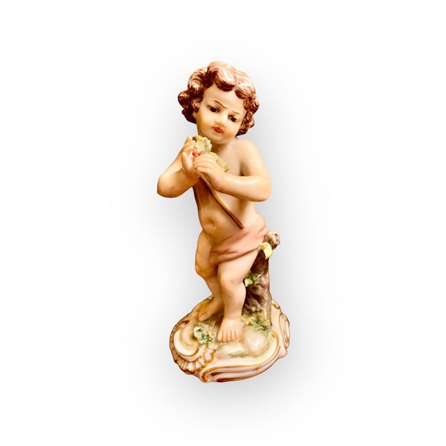 A pair of lovely figures of young children with beautiful hand painted facial features. One holds a bell and is leaning on...