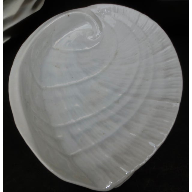 A set of 10 porcelain abalone-shaped shell dinner or salad plates. White with a slight rainbow irredescence. The plates...