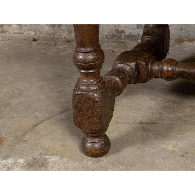 An English oak coffee table from the 19th century with single drawer, wooden pulls and turned base. Created in England...