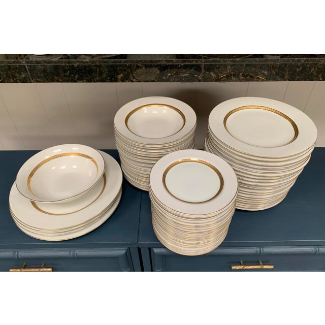 A very large, amount of white porcelain dinner set decorated with 22K gold laurel garlands. Made by Retroneu Imperial Gold...