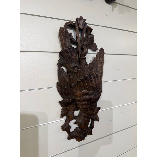 This is a dark wood Black Forest Carved Wall Plaque depicting a bird and hunting theme. It is expertly carved with leaves...