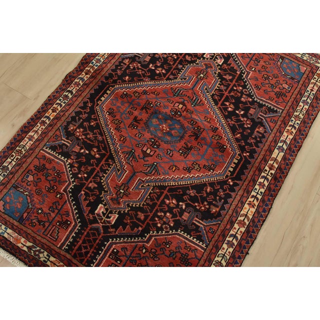 An authentic vintage tribal Zanjan rug hand-knotted with fine wool and natural dyes. This nomadic rug features a central...
