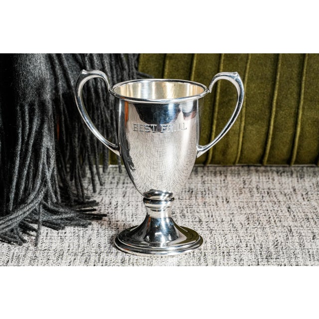 This circa 1930s double-handled trophy is a charming example of early 20th-century decorative silverplate. The trophy is...