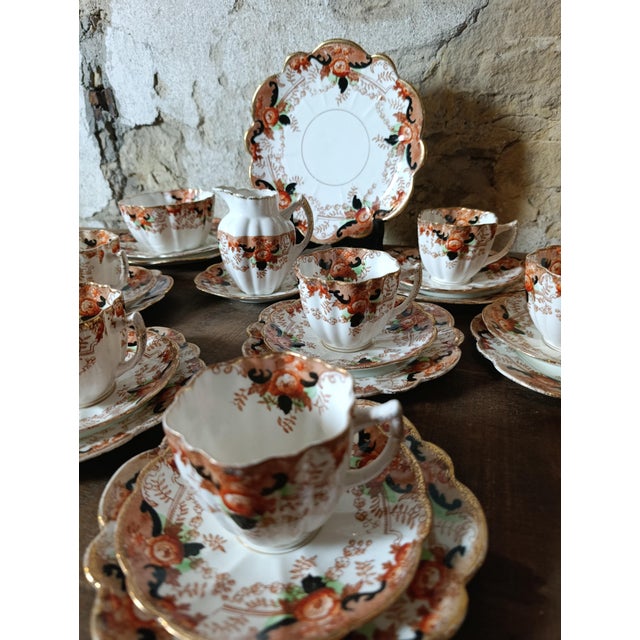 An elegant antique English tea service by Melba China, England, dating from the early 20th century. This charming set...
