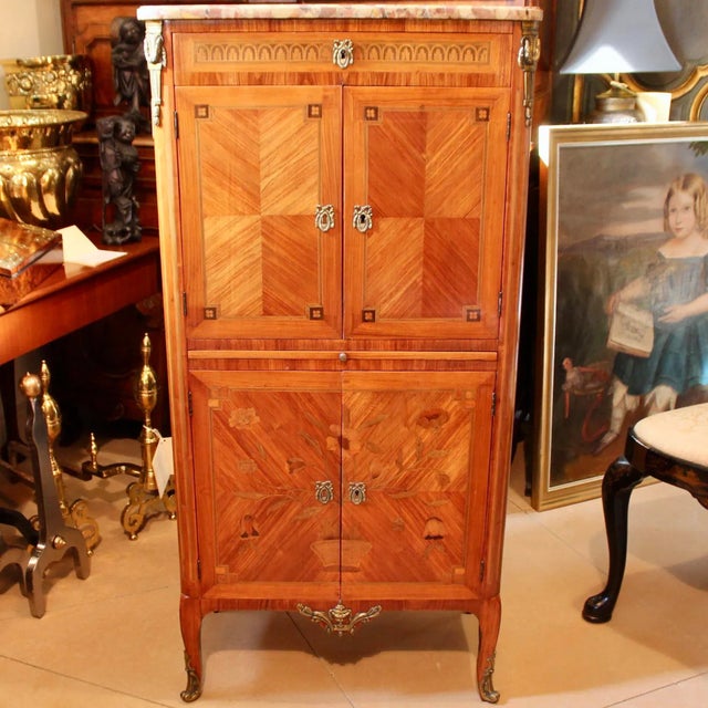 An elegant marquetry inlaid French cabinet of tulipwood. Nice quality, good timbers, finely executed floral marquetry, oak...