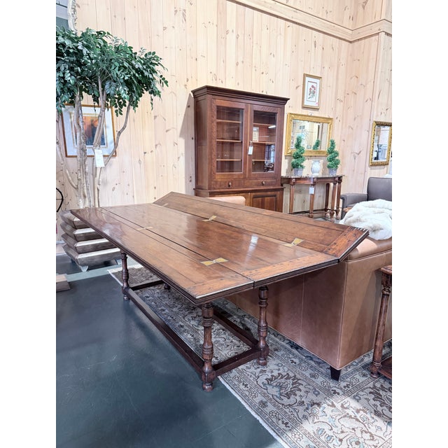 This is a richly crafted Jonathan Charles walnut hunt table featuring a long plank style top with visible joinery and warm...